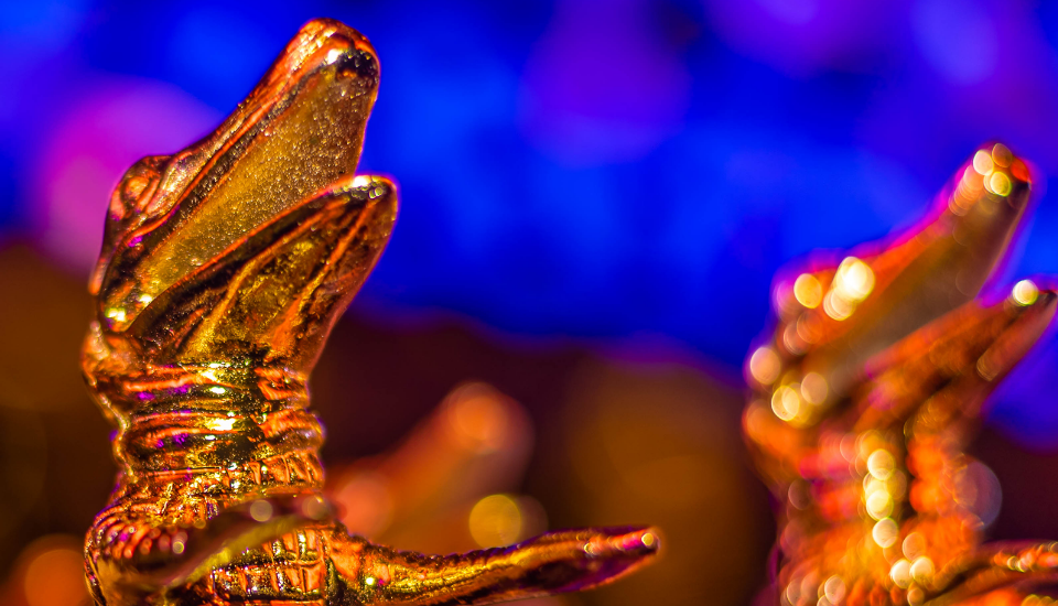 Troféu em formato de jacaré do Prêmio Caio, símbolo de excelência no setor de eventos.