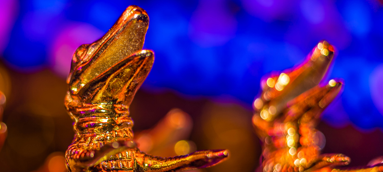 Troféu em formato de jacaré do Prêmio Caio, símbolo de excelência no setor de eventos.